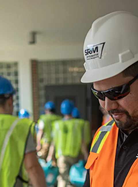 SRM worker in vest with other workers in background