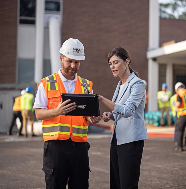 SRM employee standing outside building with woman